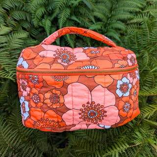 Floral-patterned bag on a green leaf background