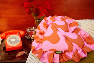 Dragstrip Disco Pink and Orange Heart-shaped cushion with ruffle edge from Weirdstock in a retro setting with roses and vintage orange telephone